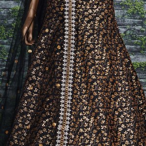 El lehenga negro intenso está cubierto con un intrincado bordado de lentejuelas doradas en forma de ramas, creando un patrón fluido y elegante para la recepción. - Product Image 4