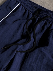 Pantalon large pour homme haut de gamme, coupe ample, base blanche avec bandes latérales noires, cordon de serrage, ajustement confortable. - Product Image 3