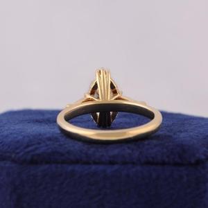 Anillo de compromiso con diamante talla marquesa en oro amarillo macizo, engaste de múltiples puntas, banda cónica sencilla y pequeñas piedras laterales. - Product Image 4