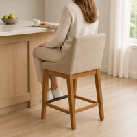 Tabouret de bar moderne rembourré avec dossier incurvé, accoudoirs fixes et base en bois pour bar à domicile ou usage commercial.