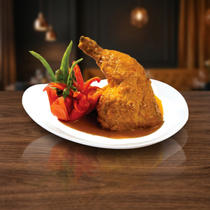 น่องไก่พร้อมซอสแกงเผ็ดและผักตกแต่งบนจานสีขาว - Product Image 1