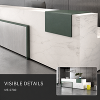Bureau de réception moderne en L en bois avec surface aspect marbre blanc, accent vert et façade grise côtelée pour projets de hall d'entrée