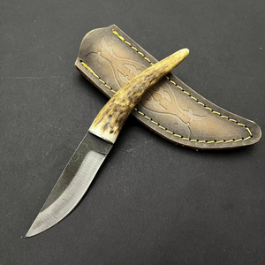 Cuchillo de caza y camping Skinner con mango de cuerno de ciervo, acero inoxidable, parcialmente dentado, grabado, de espiga completa y hoja fija. - Product Image 1