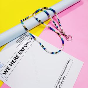 สร้อยประดับร่างกายทำมือหลากสีสันที่สวมใส่โดยผู้หญิงที่สวมเสื้อสีขาวและมีบัตรประจำตัวที่มองเห็นได้ แสดงถึงงานฝีมือของช่างฝีมืออย่างภาคภูมิใจ - Product Image 1