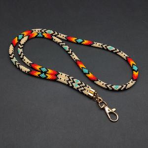 Chaîne de corps perlée faite à la main avec fermoir doré, tissée avec des motifs géométriques rouges, jaunes, oranges, turquoise, noirs et beiges, accessoire - Product Image 1