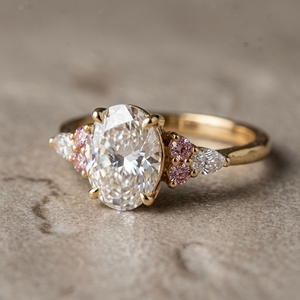 Anillo de promesa con diamante natural de corte ovalado y un único diamante rosa con diamantes laterales de corte marquesa en oro amarillo. - Product Image 1