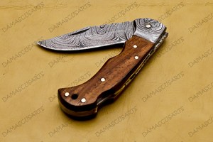 Couteau utilitaire pliant artisanal OEM en acier Damas, manche en bois naturel, contreforts en acier Damas, lame à bord dentelé de type Drop Point - Product Image 4