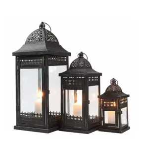 Black metal lantern trio clear glass panels ornate domed tops decorative finials warm glowing <b>candles</b> elegant traditional indoor - Product Image 1