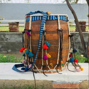 Tambour en bois sculpté avec une bandoulière bleue tressée, décoré de pompons colorés, disponible à prix de gros. - Product Image 1