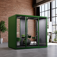 Pod de bureau moderne et créatif vert avec façade en verre, intérieur gris et espace de travail flexible pour musique ou studio