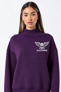 Hermosa mujer con una sudadera de cuello alto en un vibrante color rosa intenso, con delicado ribete de encaje y un audazco bordado de águila negra en el pecho. - Product Image 3