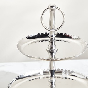 Magnifique support à gâteau à deux niveaux en argent, avec des plateaux à bords festonnés et un tige centrale en métal ornée d'un anneau rond. - Product Image 2
