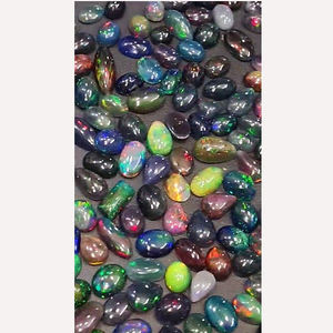 โอปอลดำเอธิโอเปียธรรมชาติ 345 ชิ้น พร้อมประกายไฟ ขนาด 8 มม. ถึง 16 มม. รูปทรงวงรี ลูกแพร์ แปดเหลี่ยม คาโบชอง น้ำหนัก 405 กะรัต ขายโดย Iroc Sales Gemstone cab ราคา 260 ดอลลาร์สหรัฐ - Product Image 1