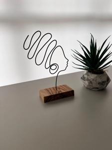 Escultura minimalista de rostro en alambre sobre base de madera, ideal para decoración de un rincón de lectura en el hogar y para combinar con libros como arte en la estantería. - Product Image 3