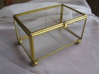 Boîte à bijoux rectangulaire en verre avec cadre doré et détail de chaîne