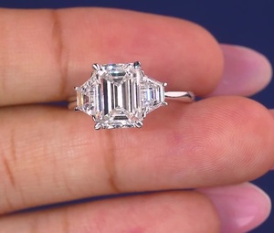 Bague minimaliste de luxe avec diamant de laboratoire taille émeraude, certifiée IGI, sertie de trois pierres avec pierre trapézoïdale latérale - Product Image 1