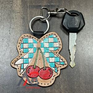 Nouveau porte-clés personnalisé en cuir véritable à motif damier, fait main, avec anneau métallique et design nœud cerise, pour unisexe - Product Image 1