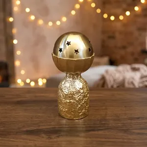 Brûle-encens en métal doré avec base texturée et dessus sphérique découpé en étoiles, parfait pour une ambiance chaleureuse et une décoration essentielle. - Product Image 1