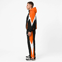 Ensemble de survêtement pour homme noir, orange et blanc avec blocs de couleur, veste coupe-vent zippée intégrale et pantalon sportif avec logo imprimé