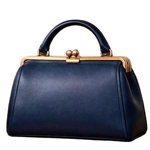 Este artículo es un bolso de mano para mujer de color azul oscuro, con un estilo similar a los diseños retro o vintage de bolsos con cierre de beso. - Product Image 1