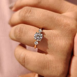 Anillo de compromiso refinado con tres piedras, diamantes redondos y un delicado halo oculto. - Product Image 2