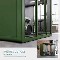 Pod de bureau moderne et créatif vert avec façade en verre, intérieur gris et espace de travail flexible pour musique ou studio