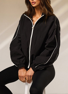 Chaqueta cortavientos negra personalizada al por mayor con logo, para mujer, con cremallera completa, cuello tipo embudo y ribetes en contraste, tela con ligeras arrugas. - Product Image 4