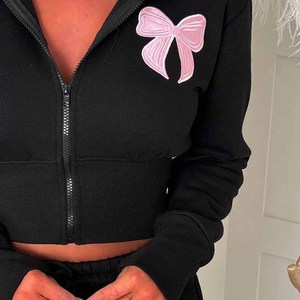ชุดกางเกงขาสั้น 2 ชิ้นสำหรับผู้หญิง เสื้อฮู้ดครอปสีดำพร้อมปักโบว์สีชมพู แขนยาว ชุดกีฬาลำลอง ความยาวเหนือเข่า - Product Image 2