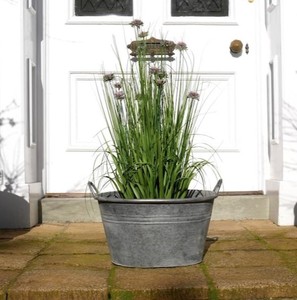 Pot de fleurs en métal rustique, design circulaire, finition durable pour une utilisation en jardin avec des plantes vertes - Product Image 1