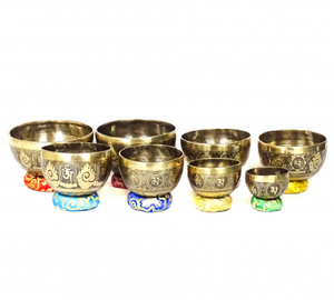 Juego de cuencos tibetanos de latón grabados con los siete chakras sobre cojines de seda coloridos, disponible a precio de mayorista. - Product Image 1