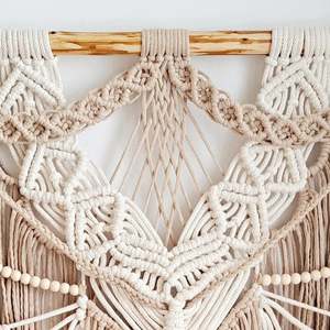 Décoration murale en macramé faite à la main, style bohème, avec franges à pompons, tons terre naturels, forme irrégulière, art textile - Product Image 1