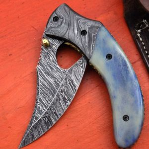 Cuchillo de caza de acero de Damasco con hoja de punta caída, borde dentado, mango azul y apertura con perilla para el pulgar - Product Image 1