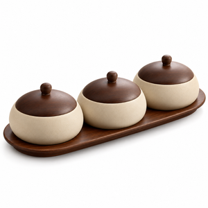 Juego de tres piezas de recipientes redondos de cerámica color crema con tapas abovedadas marrones, asas y bandeja de servir de madera. |   Organizador de encimera - Product Image 1