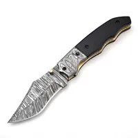 Couteau pliant à manche sculpté noir avec lame à motifs, poignées argentées et garnitures dorées, idéal pour le camping et la collection