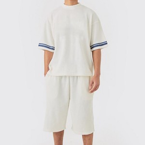 Conjunto de camiseta y pantalones cortos de punto color crema para hombre, cuello redondo, manga corta, color sólido, transpirable, informal, para verano. - Product Image 1