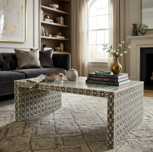 Mesa de centro ovalada con un diseño de incrustaciones geométricas y en forma de estrella en blanco y negro, sobre cuatro patas delgadas de latón. - Product Image 2
