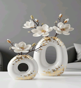 Elegantes jarrones blancos con forma de donut, adornados con hojas doradas y magnolias de seda. Decoración moderna disponible a precios de mayorista. - Product Image 1