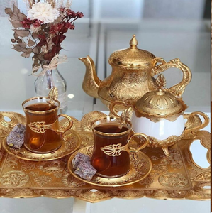 Elegante juego de té turco de oro con vasos transparentes, una azucarera blanca y dulces. Disponible a precios de mayorista. - Product Image 1