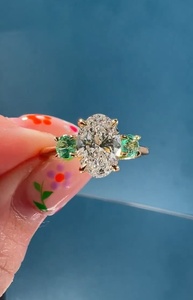 Bague à trois pierres en or 14 carats avec diamant ovale de 3,01 carats cultivé en laboratoire et pierres précieuses vertes rondes latérales, idéale pour fiançailles, promesse, fête ou comme cadeau. - Product Image 3