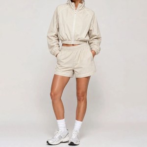 Conjunto deportivo de 2 piezas beige para mujer con logotipo personalizado, chaqueta con cremallera y pantalones cortos, conjunto transpirable de poliéster para entrenamiento de primavera/verano - Product Image 1