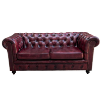 Canapé de luxe en cuir bordeaux avec capitonnage profond, accoudoirs roulés, garniture cloutée, structure en bois, écologique, élégant, style vintage pour salon