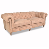 Canapé Chesterfield haut de gamme deux places en cuir avec dossier profond matelassé, accoudoirs roulés, structure en bois massif, assise confortable pour salon.