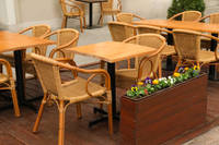 Une table à manger ronde et quatre chaises en rotin tressé, un ensemble de meubles de cuisine et de restaurant luxueux. Chaises de jardin.