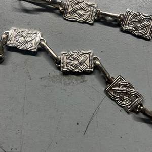 Ce produit est un accessoire vestimentaire des Highlands, décrit comme une chaîne sporran à motif celtique en nickel avec sangles en cuir noir. - Product Image 4