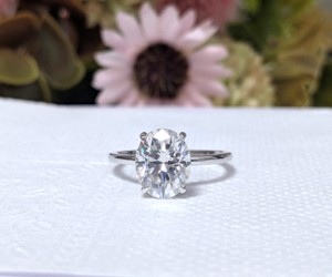 Anillo de compromiso de oro blanco de 14K con moissanita de corte ovalado y engaste de garras, certificado, moderno, con halo oculto, de Lurba Jewels para mujer - Product Image 1