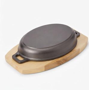 Sartén ovalada de hierro fundido con base de madera para servir bistec, mariscos, verduras y platos calientes en restaurantes. - Product Image 4