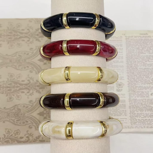 Ensemble élégant de bracelets en résine segmentés superposés avec anneaux en métal doré, présentés sur un présentoir, disponibles à prix de gros. - Product Image 1
