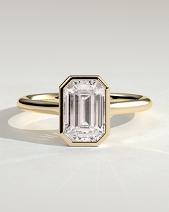 แหวนหมั้นเพชรเม็ดเดี่ยวทรงสี่เหลี่ยมมรกต 1 กะรัต ทองคำแท้ 14K ฝังแบบ Bezel Set เพชรเพาะเลี้ยงในห้องปฏิบัติการ รับรองโดย IGI เกรด E VVS2 เพชร CVD ผลิตตามแบบ OEM - Product Image 1