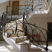 Gebogene Eisentreppe mit handgeschmiedeten Balustraden und Geländern, individuelles Design für Luxuswohnungen