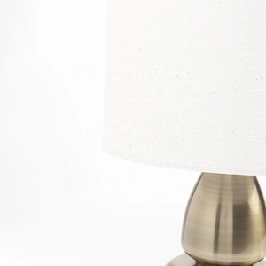 Aurora Sculpted Metal Table <b>Lamp</b> with Linen Drum Shade Antique Brass Finish Soft Ambient Lighting for Elegant Interiors - Product Image 4
